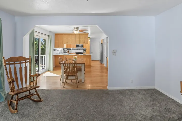 Kitchen with arched walkways, light carpet, a peninsula, stainless steel appliances, and a breakfast bar area