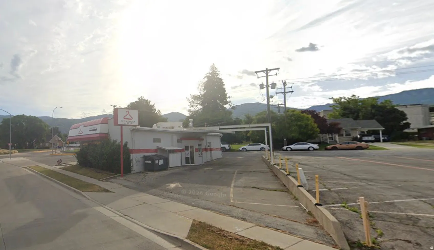 View of asphalt street with sidewalks, street lights, and curbs