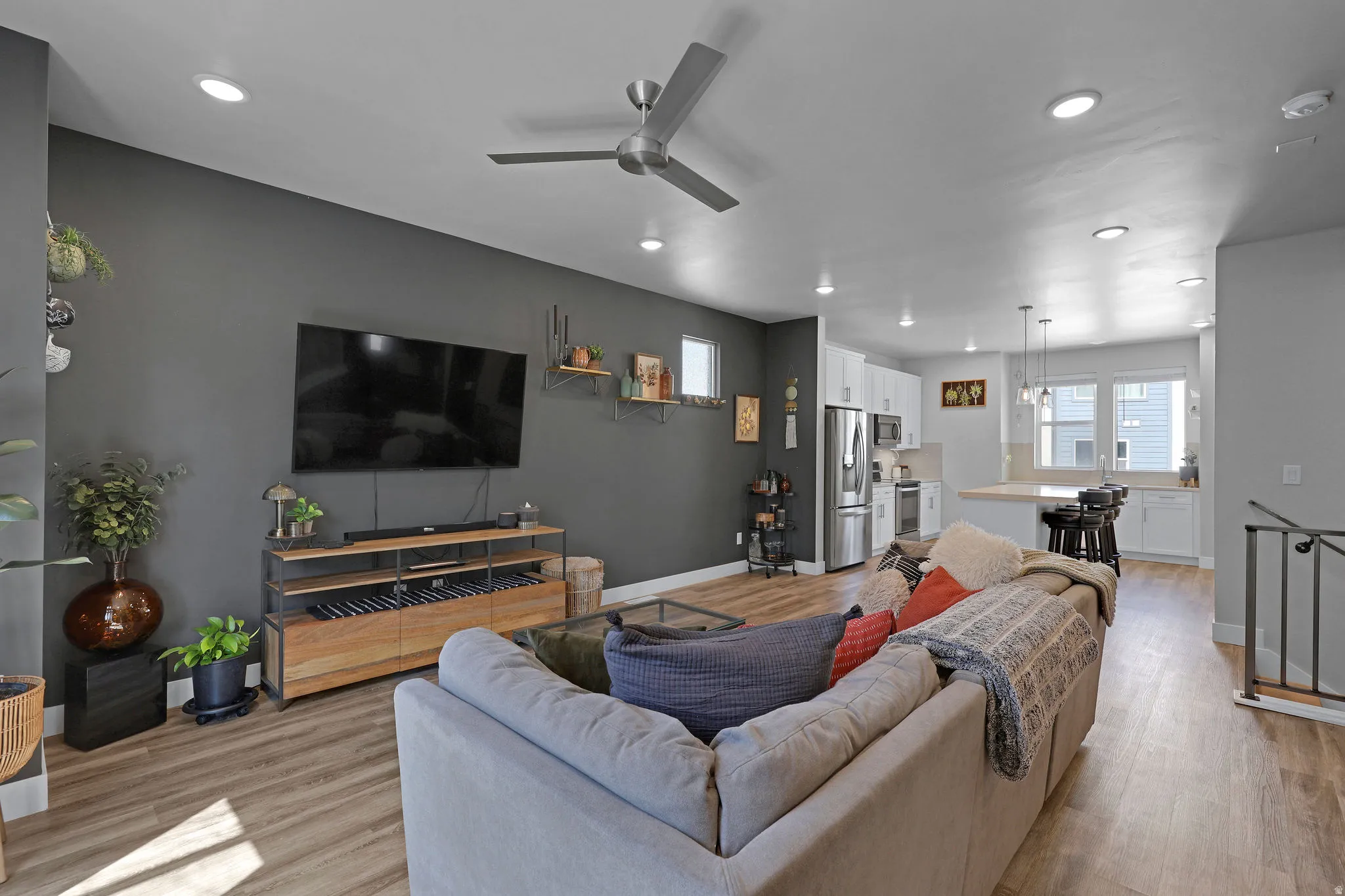 Living room featuring ceiling fan, light wood finished floors, and recessed lighting