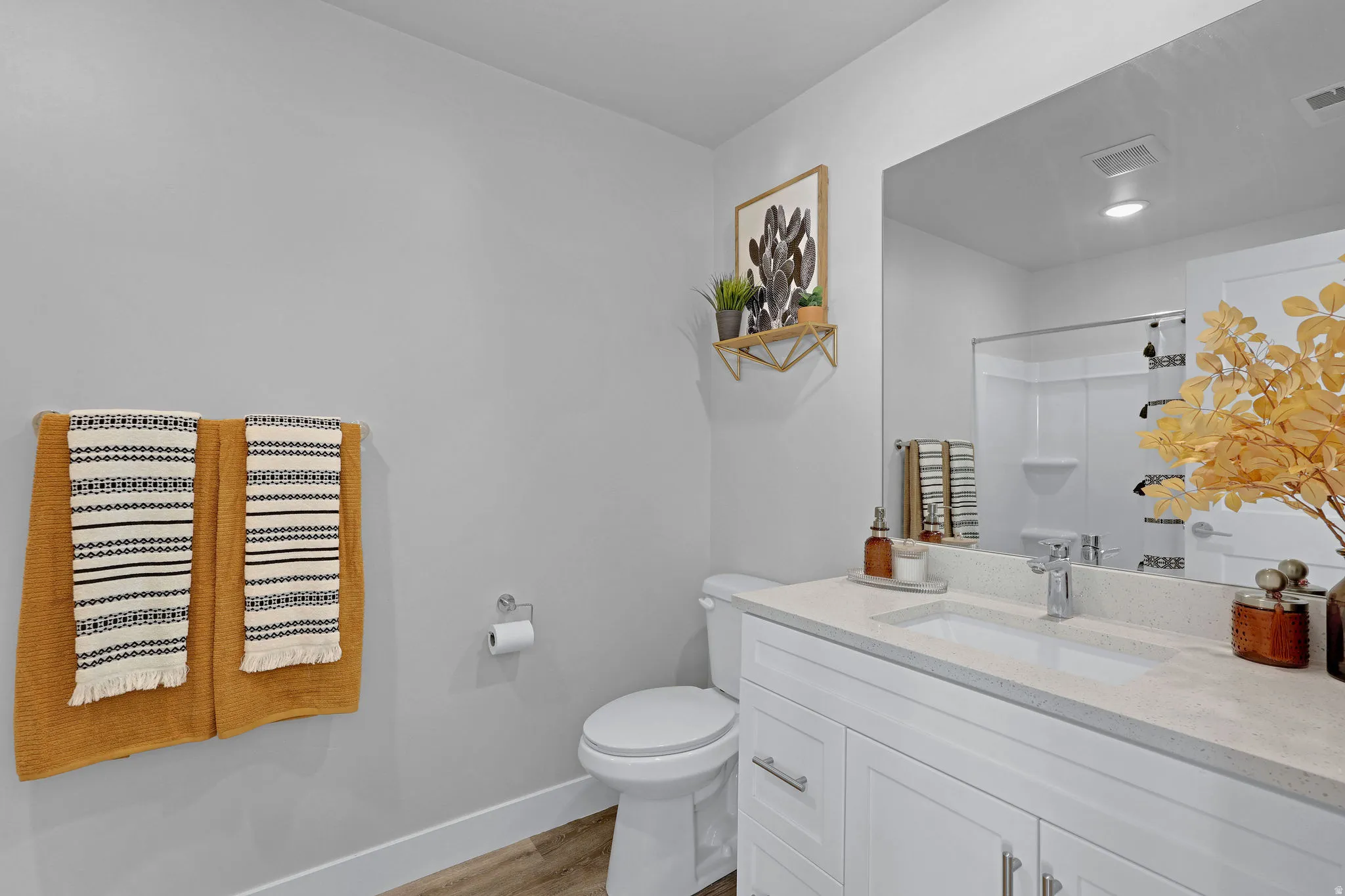 Bathroom with vanity, a shower, and light wood-style flooring