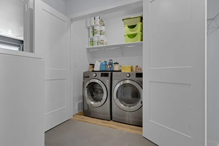 Laundry area with independent washer and dryer and light wood-style floors
