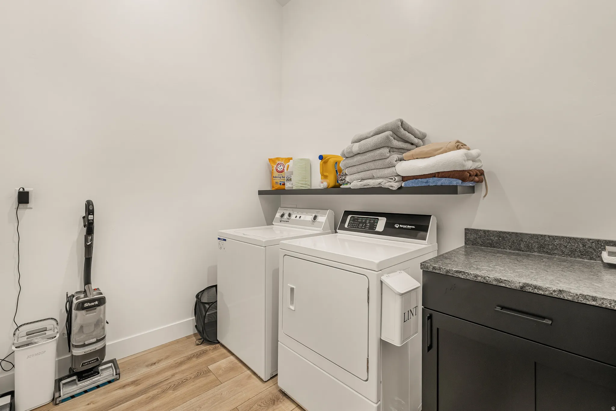 Laundry room with light wood-style flooring and independent washer and dryer
