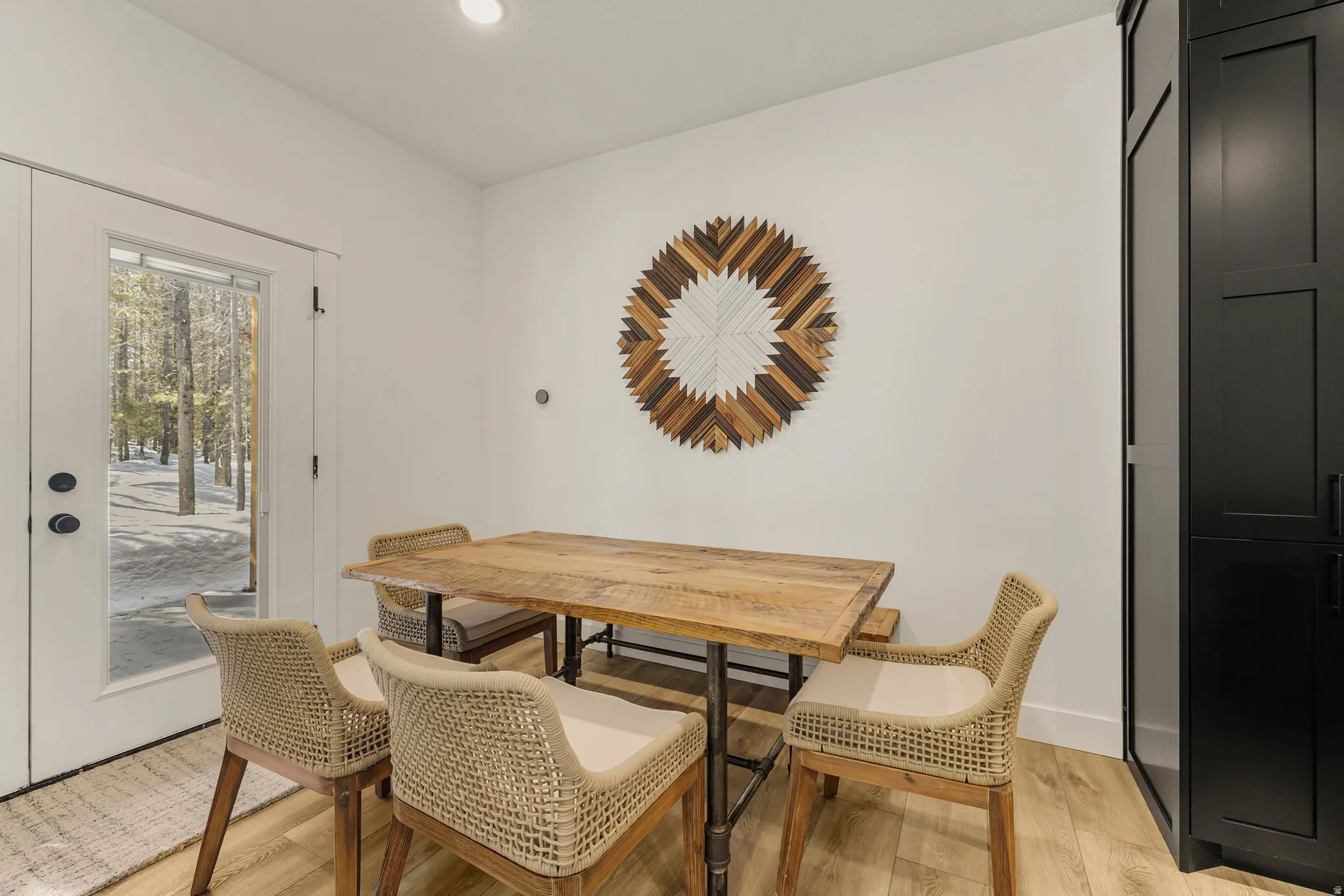 Dining room with light wood finished floors and recessed lighting