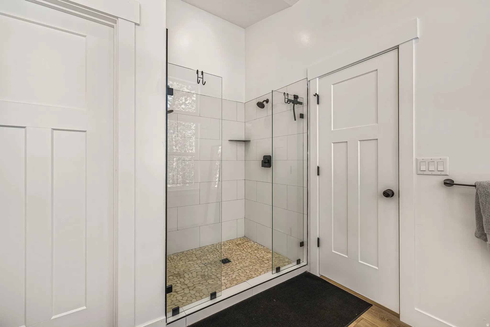 Full bathroom featuring a stall shower and wood finished floors