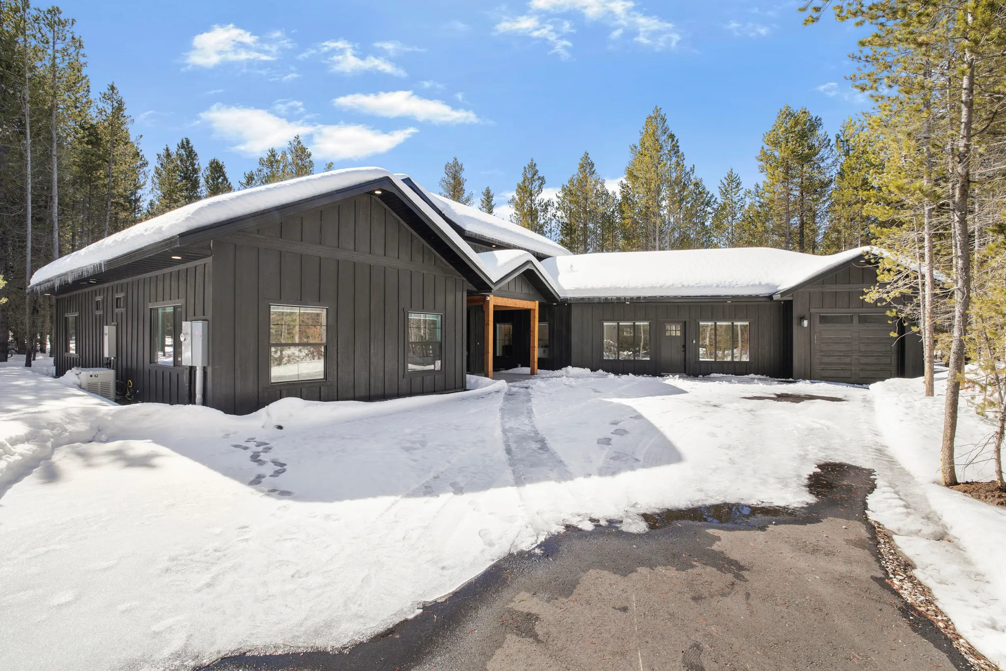Rustic home with board and batten siding, an attached garage, and roof mounted solar panels