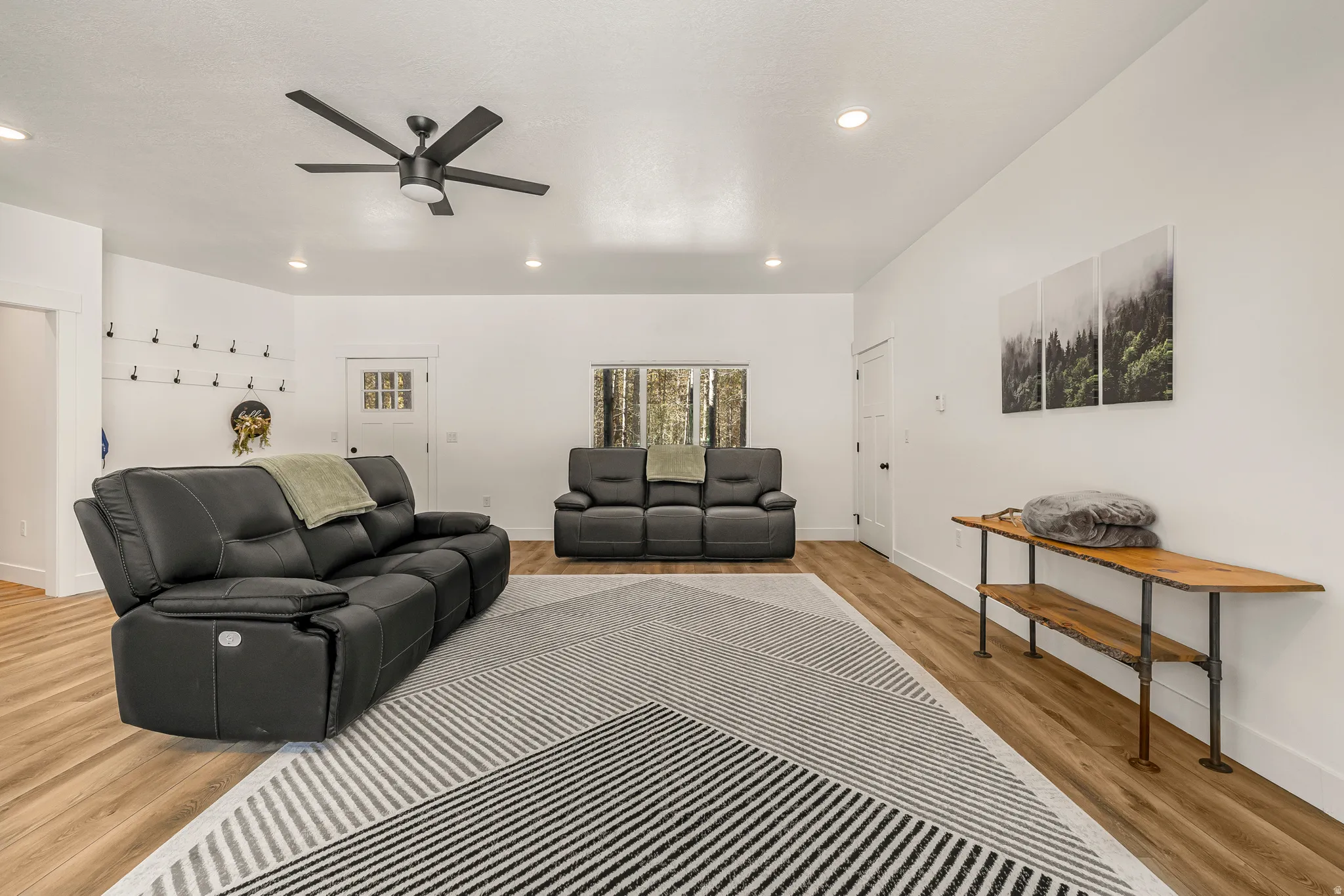 Living room with light wood-style floors and ceiling fan