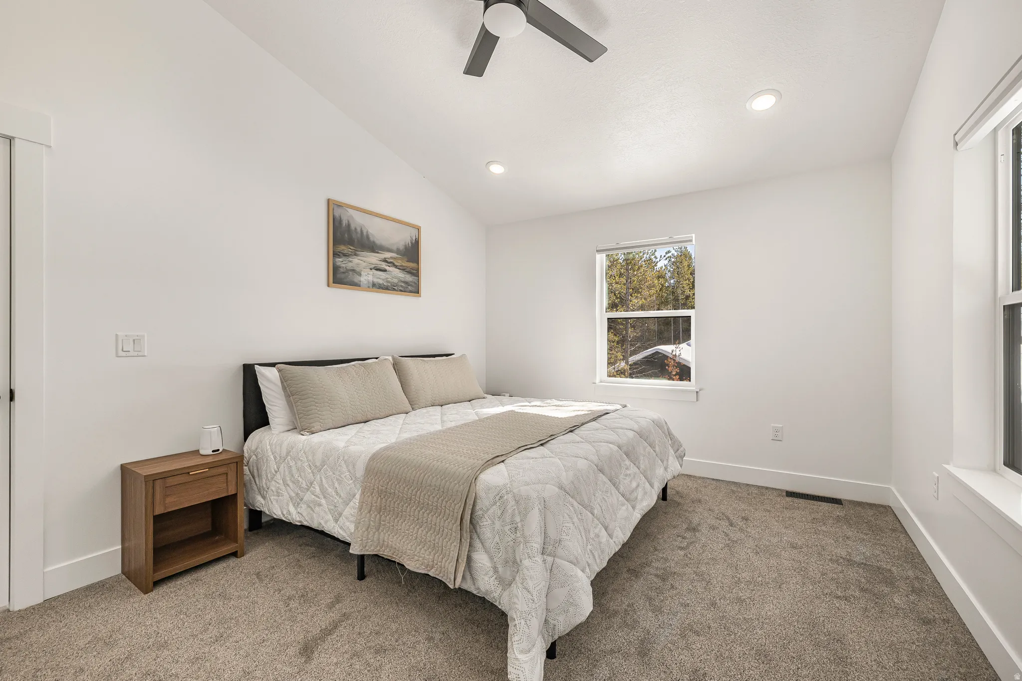 Carpeted bedroom featuring vaulted ceiling, ceiling fan, and recessed lighting