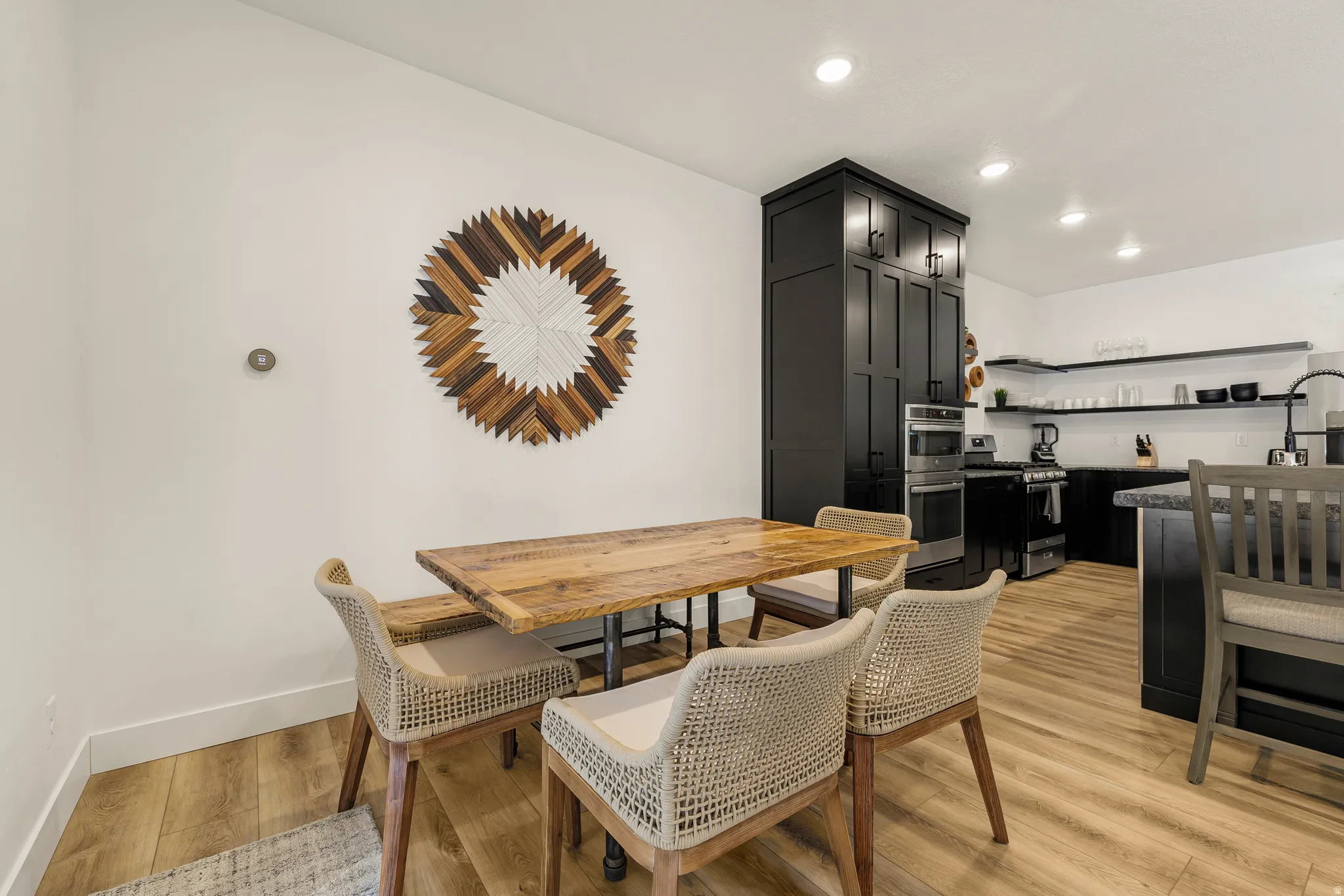 Dining area with light wood-style flooring and recessed lighting