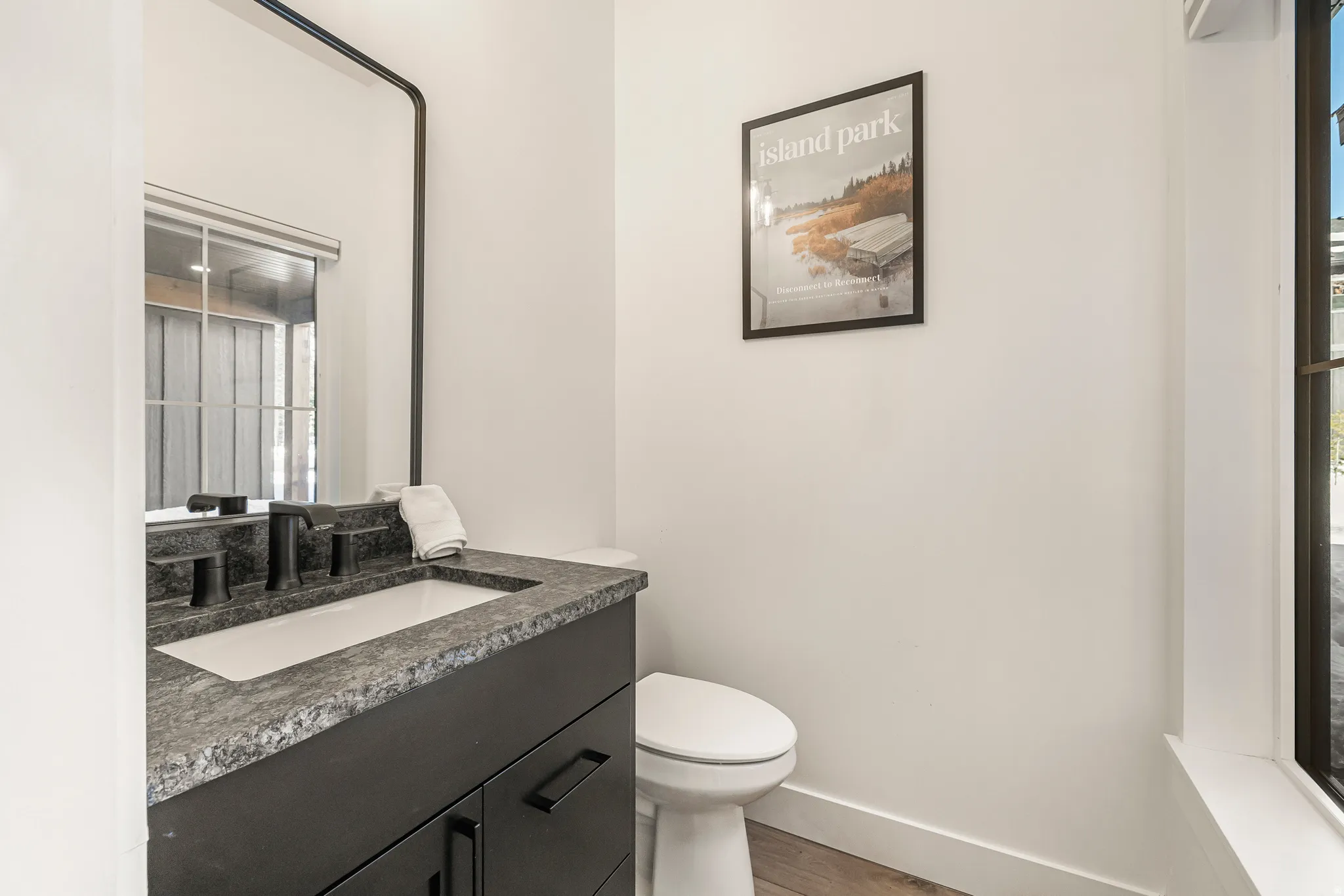 Half bathroom with vanity and light wood finished floors