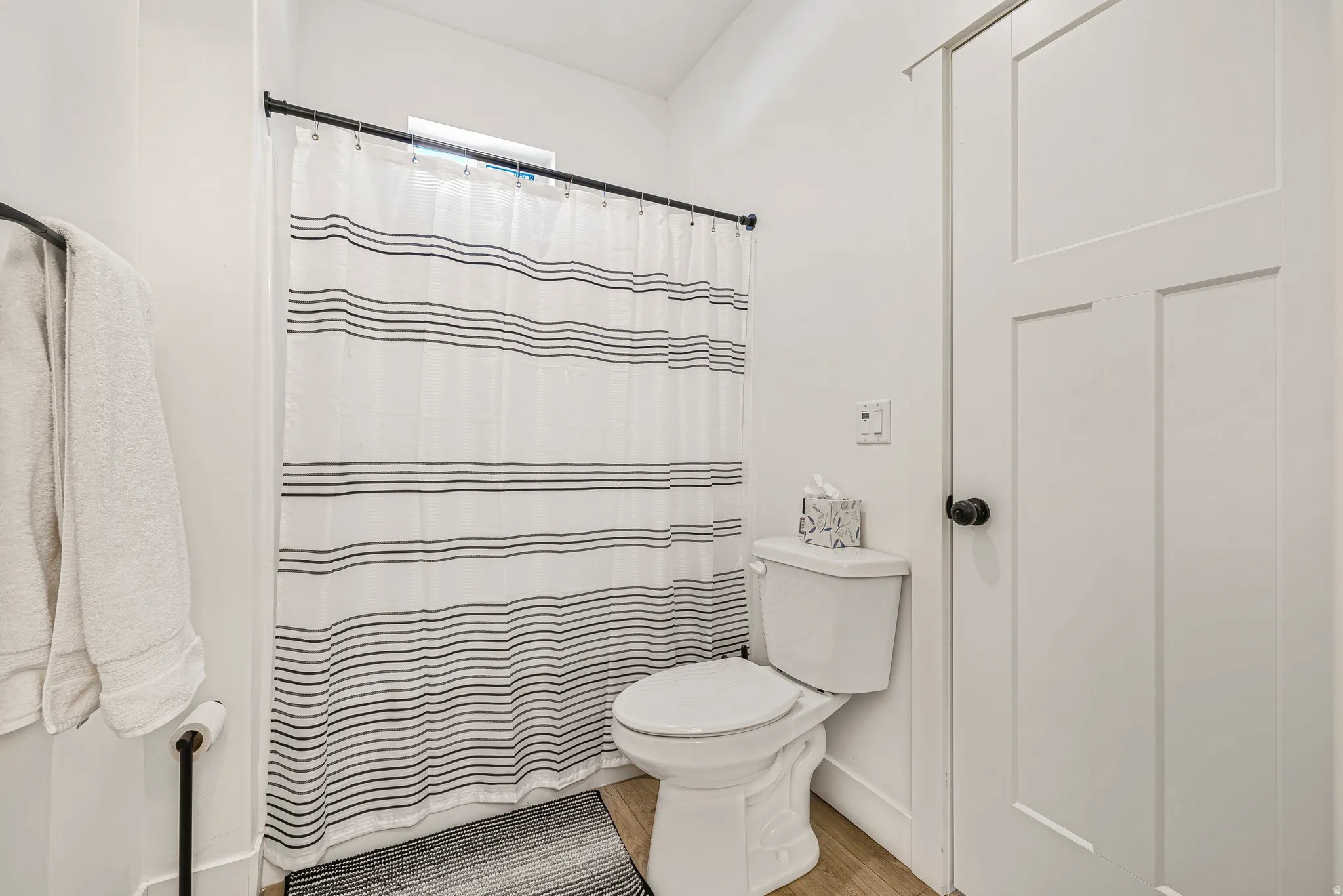 Bathroom featuring toilet and light wood finished floors