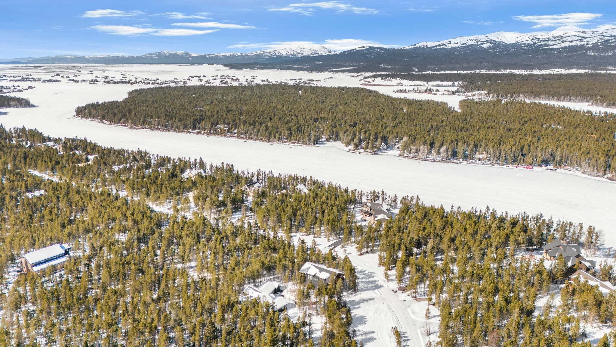 Bird's eye view of a mountain backdrop and a heavily wooded area
