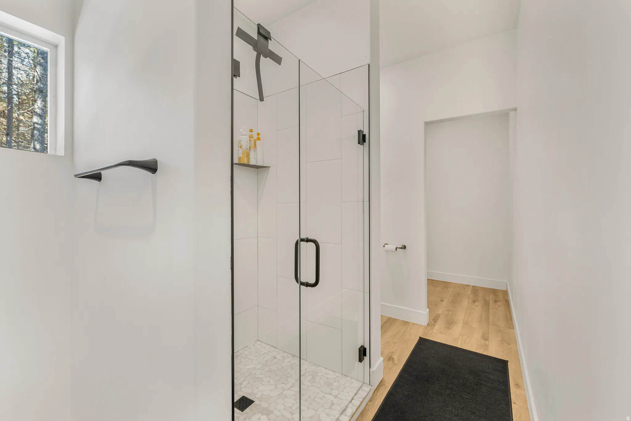 Full bathroom with a stall shower and light wood finished floors