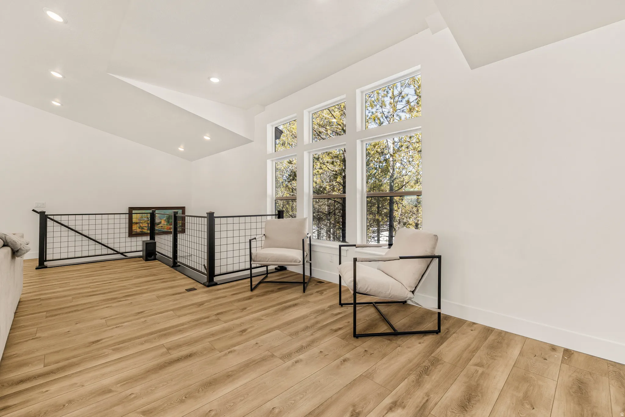 Living area featuring light wood finished floors, lofted ceiling, and recessed lighting