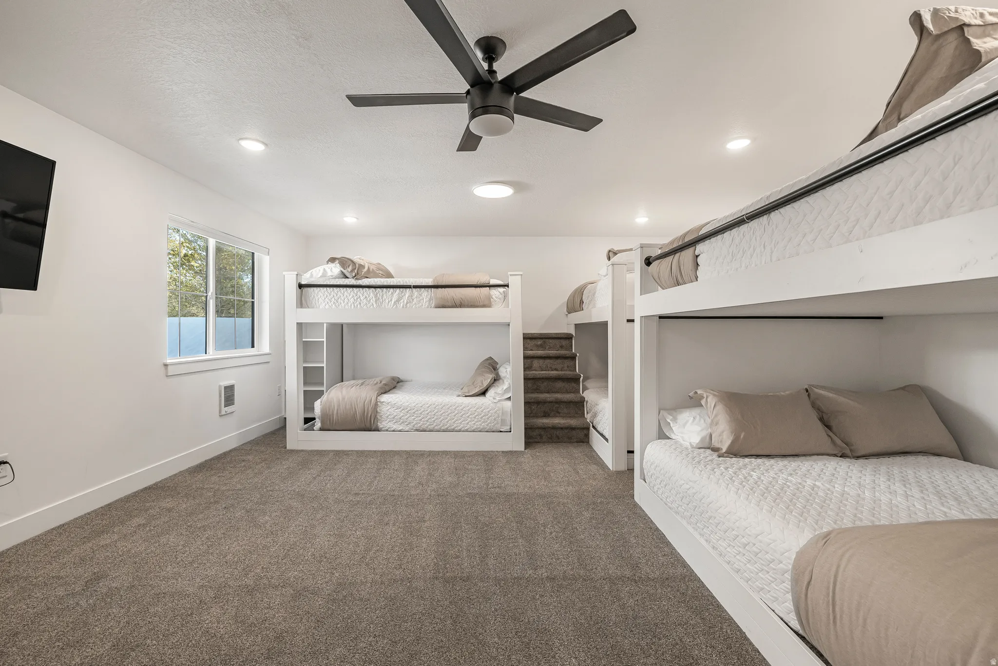Carpeted bedroom with ceiling fan, heating unit, and recessed lighting