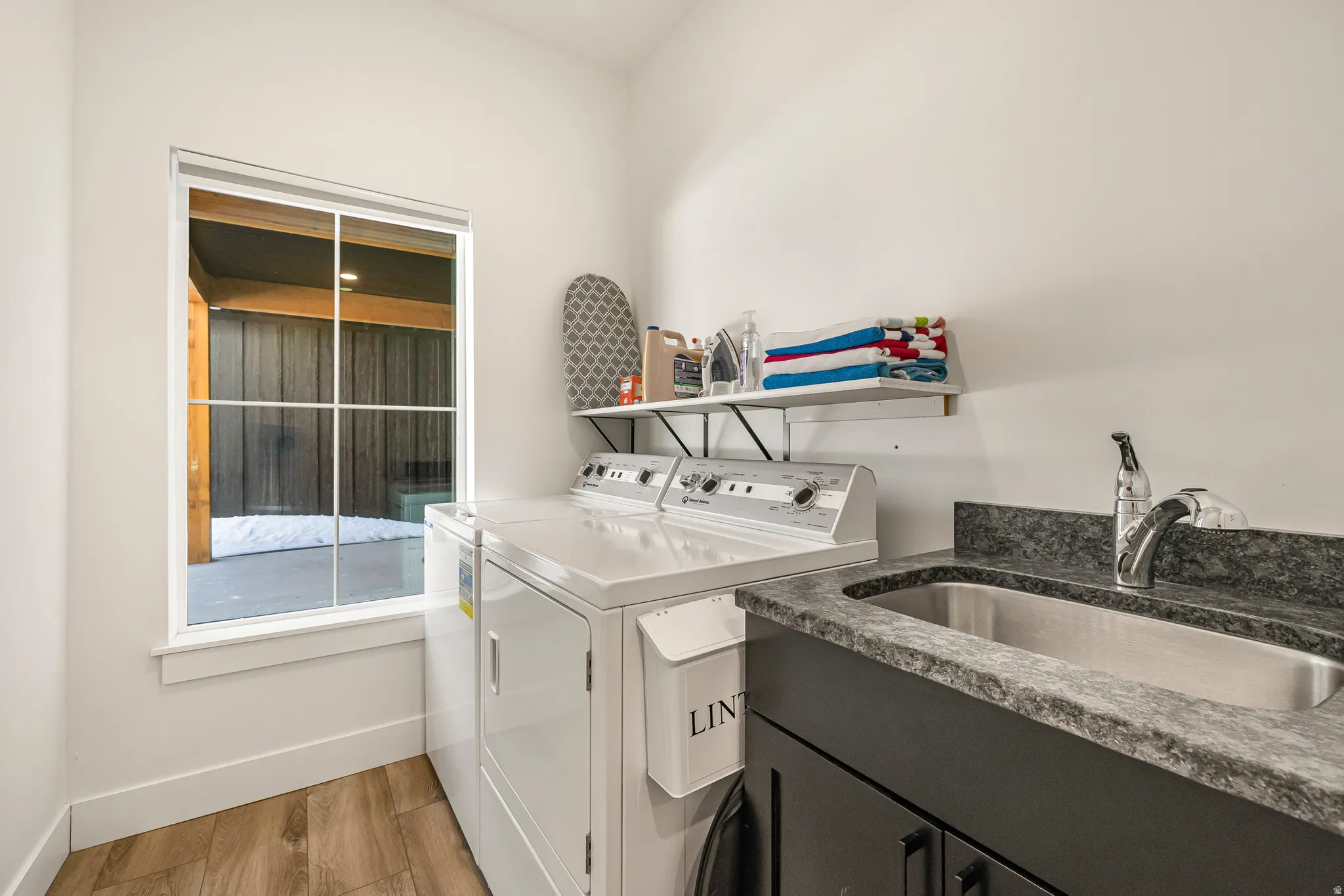 Laundry area featuring light wood finished floors, independent washer and dryer, and cabinet space