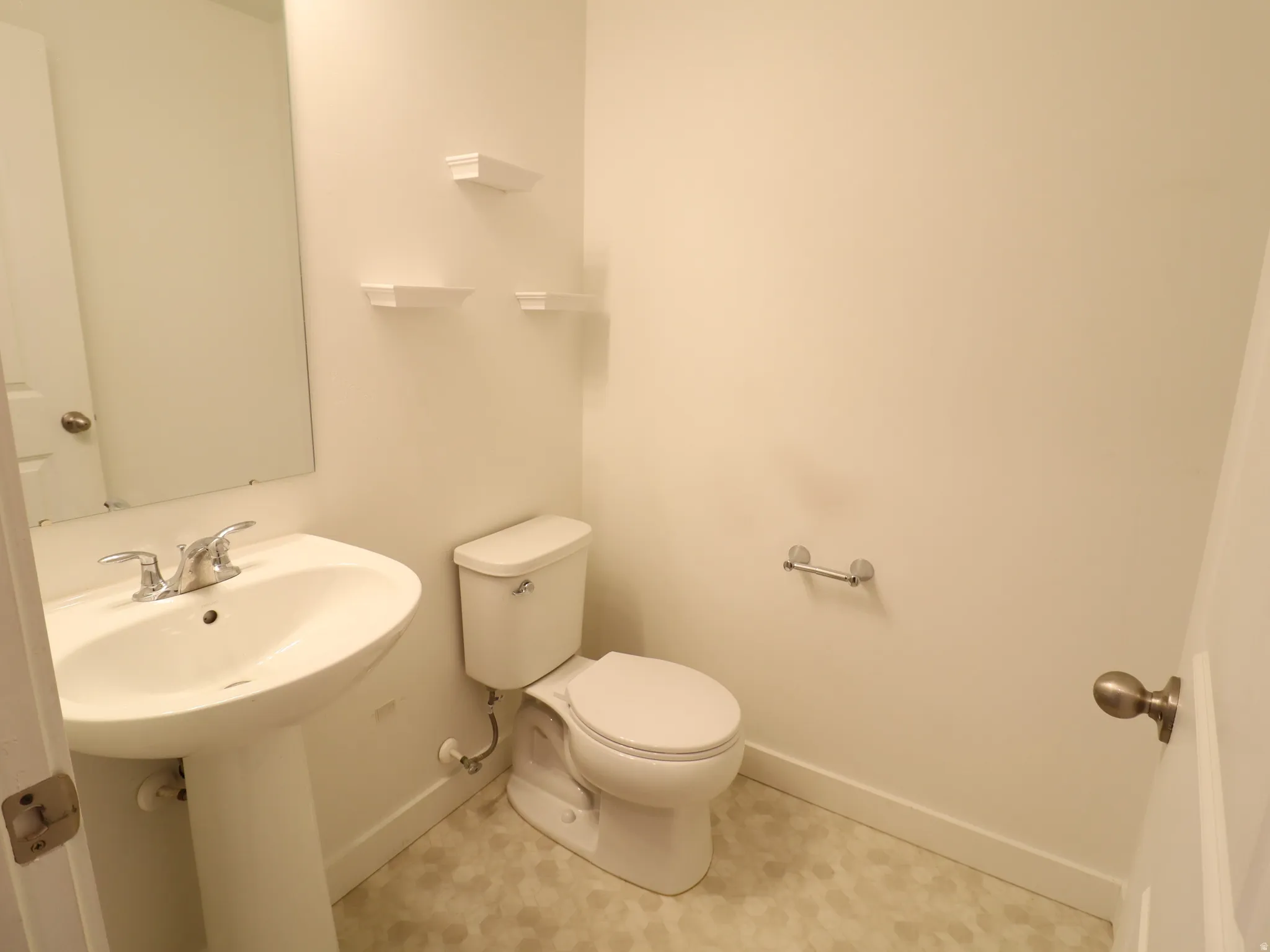Half bath featuring toilet and baseboards