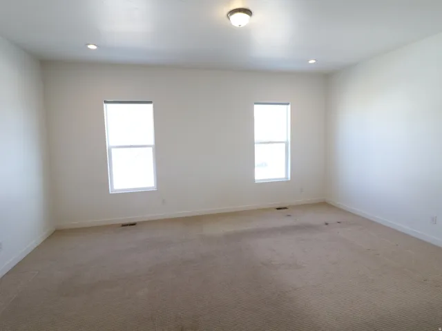 Spare room with light carpet and baseboards