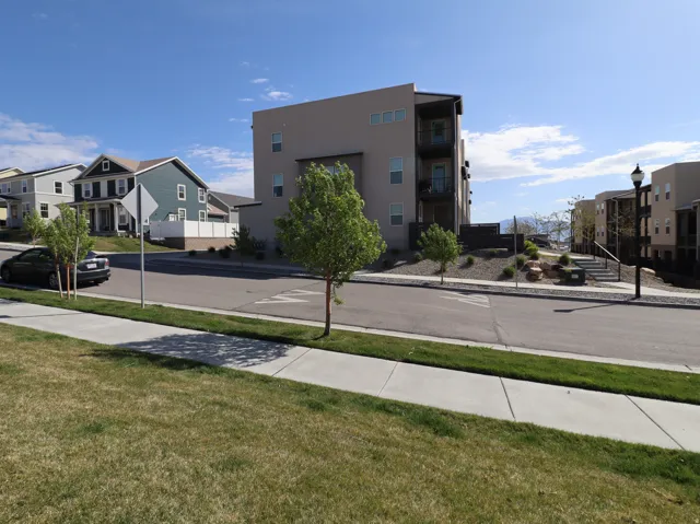 View of asphalt street featuring sidewalks, traffic signs, a residential view, and curbs