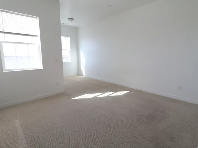 Carpeted empty room featuring baseboards