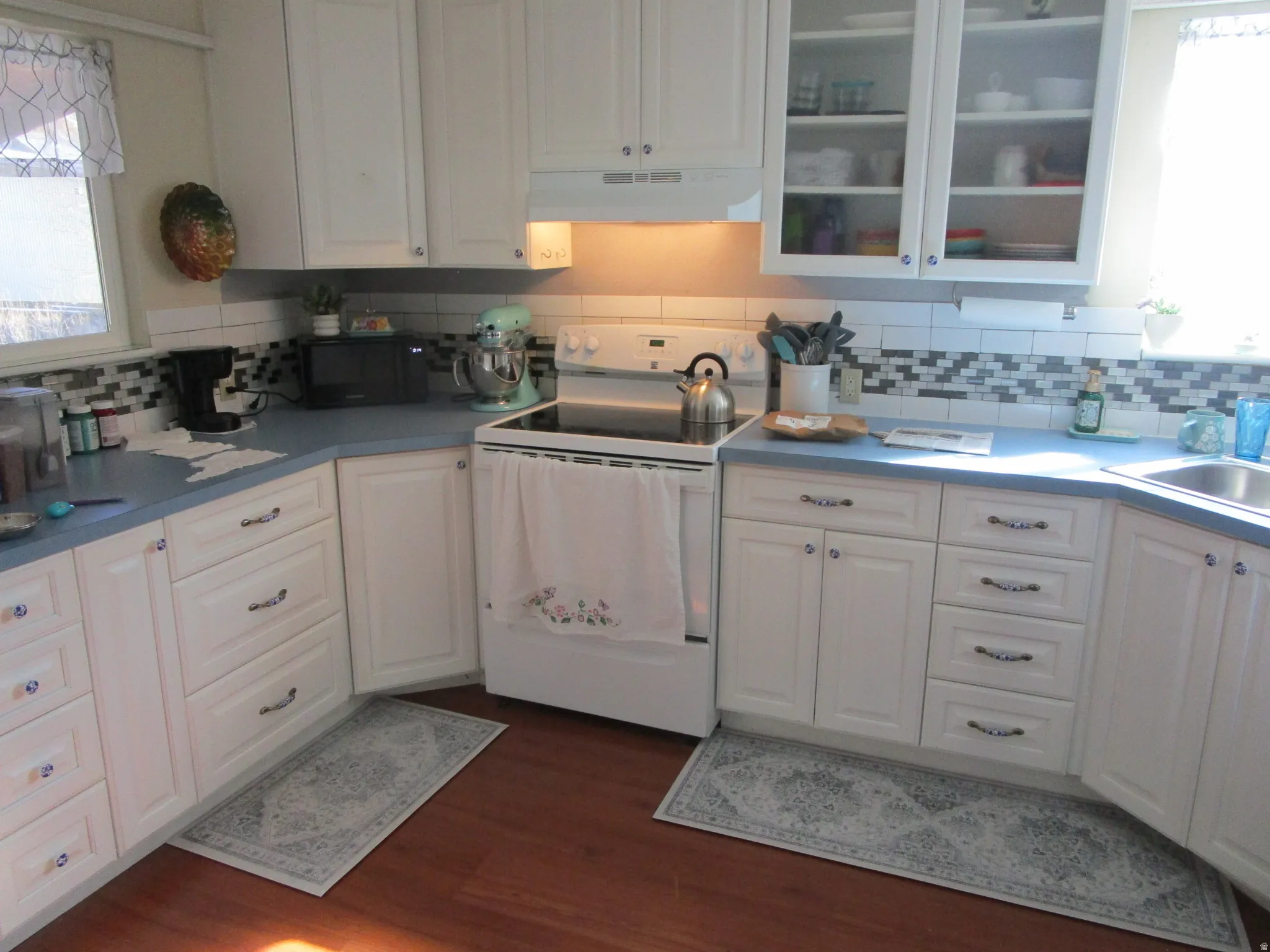 Kitchen with healthy amount of natural light, white range with electric stovetop, and white cabinetry
