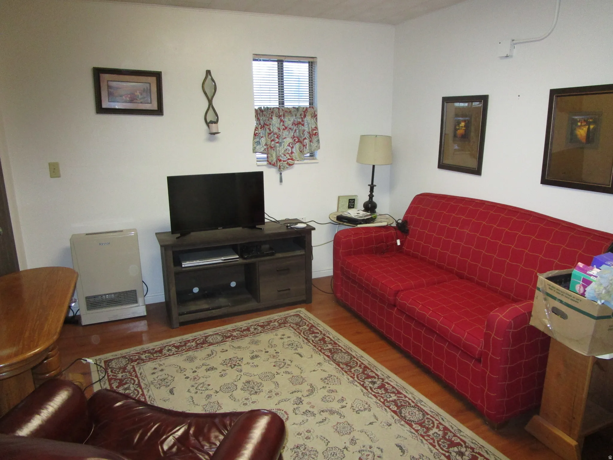 Living area with wood finished floors and heating unit