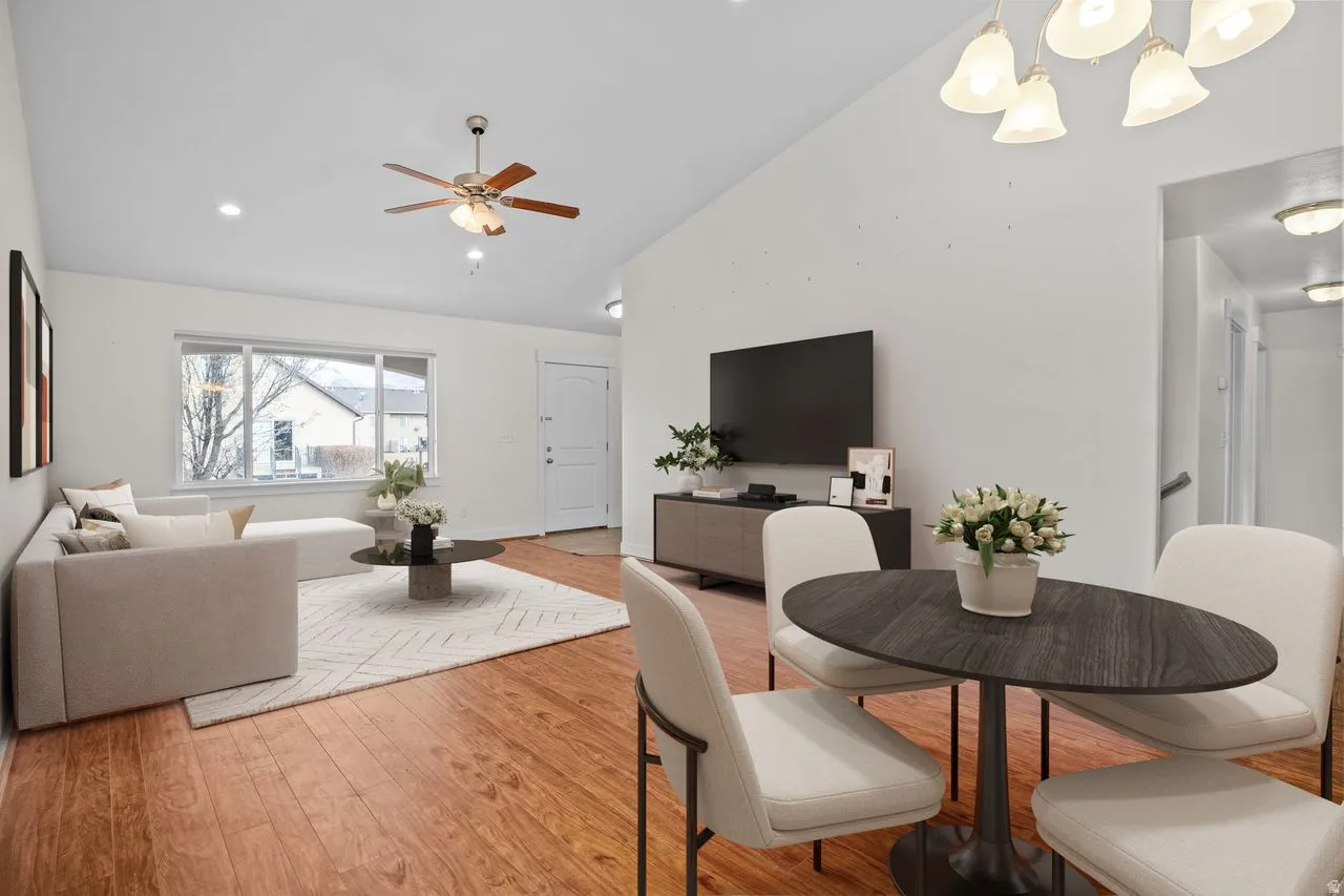 Dining room featuring light wood-style flooring, vaulted ceiling, and a ceiling fan