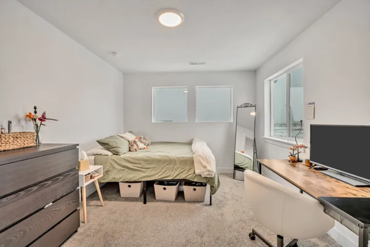 Bedroom featuring light carpet and baseboards