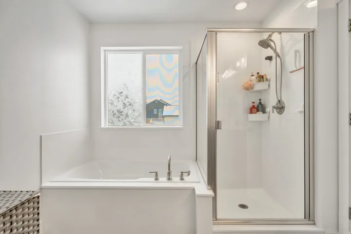 Full bathroom featuring a stall shower and a garden tub