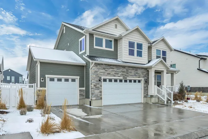 Craftsman-style house with stone siding, concrete driveway, and an attached garage