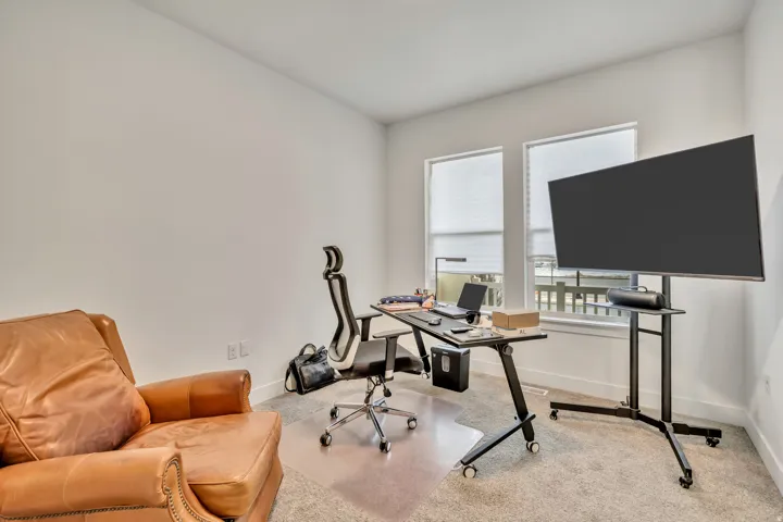 Carpeted home office featuring baseboards