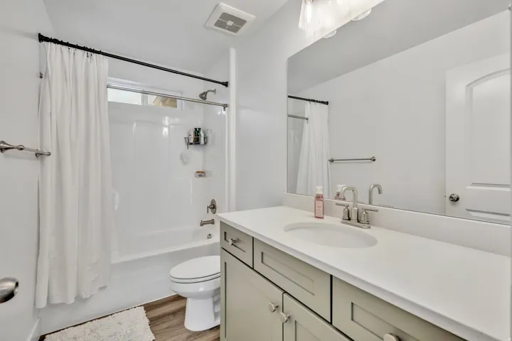 Full bathroom featuring vanity, shower / bathtub combination with curtain, and light wood-type flooring