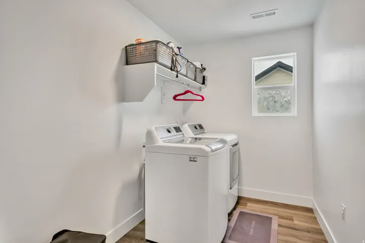 Laundry area featuring light wood finished floors and washer and dryer