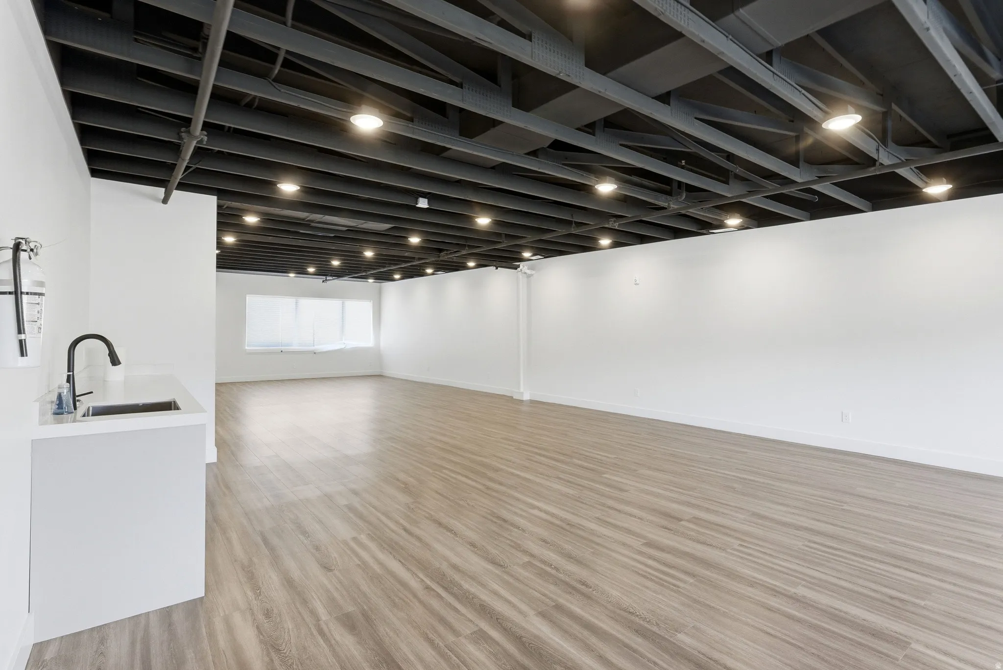 Below grade area featuring light wood-style floors and a sink