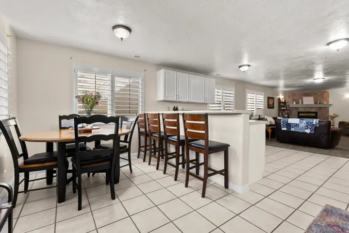 Downstairs dining area with table and bar with a healthy amount of natural light