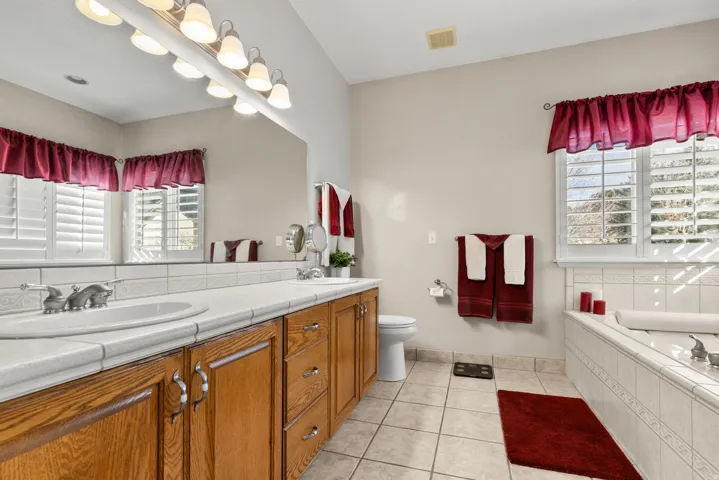 Primary bathroom with double vanity, a garden tub, shower and light tile floors