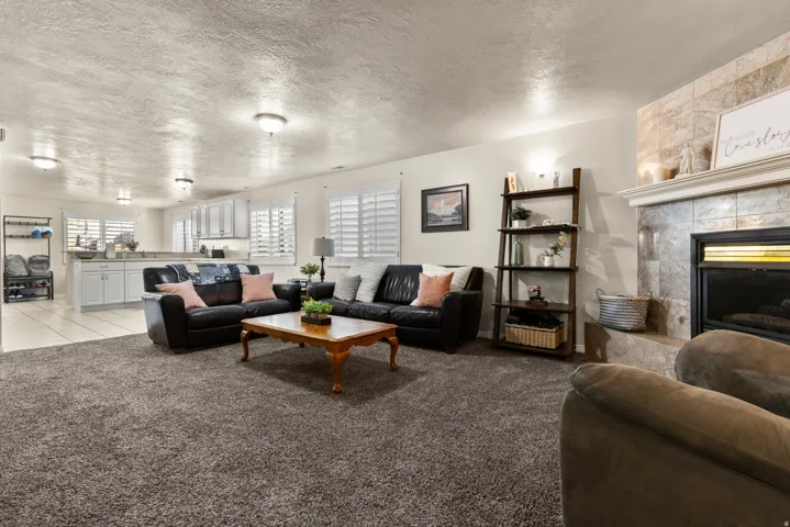 Family room featuring a textured ceiling, a fireplace, and carpet