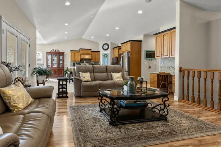 Family room with light wood-style floors, vaulted ceiling, and recessed lighting