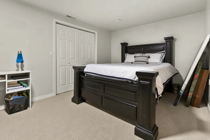 Bedroom with light carpet and a large closet