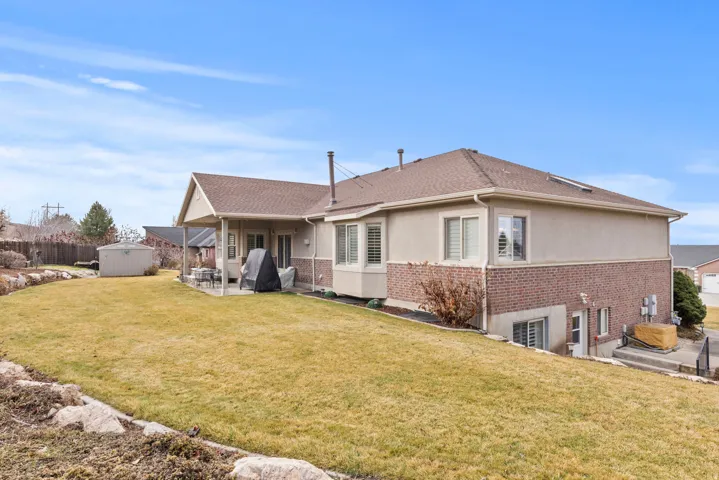 Back of house with lawn, and landscaped garden area along the back edge of property