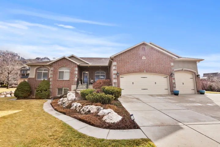 Ranch-style home with a four car garage, brick siding, concrete driveway, a front yard, and a porch