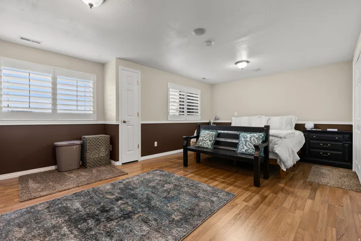 Large bedroom featuring light wood finished floors, multiple windows, and a large closet