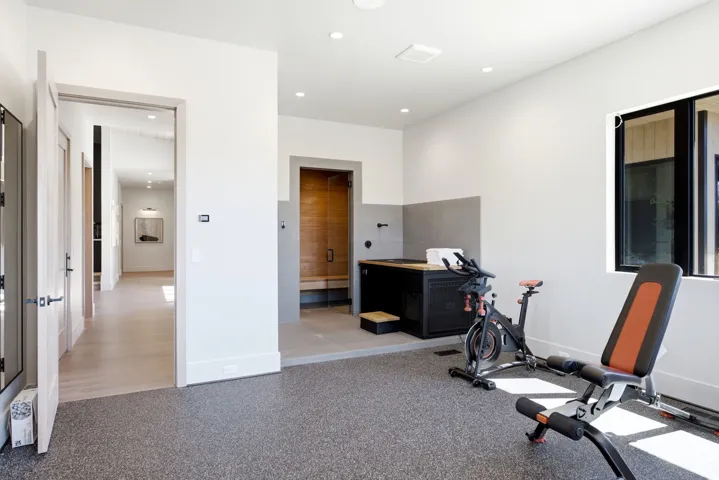 Recessed lighting, wood-finish flooring, sauna with wood paneling, black-framed window, textured flooring