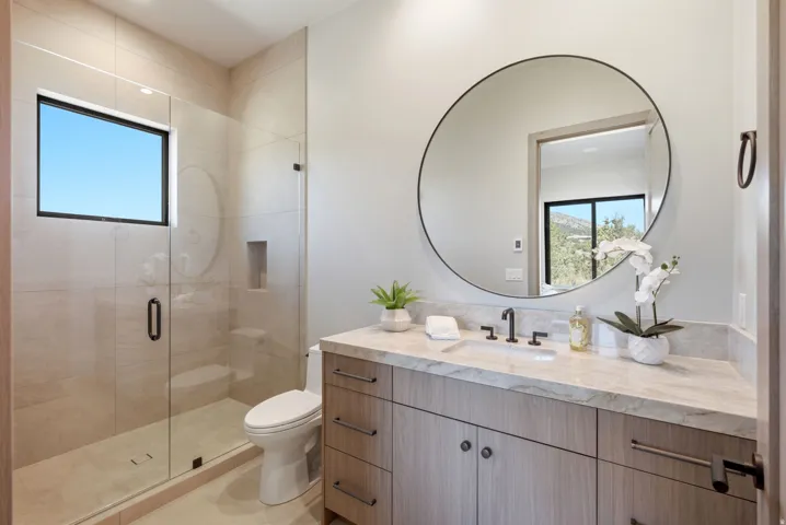 Modern vanity with a light wood-finish and stone countertop