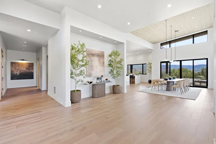 Light wood-finish flooring throughout, recessed ceiling lighting, and a vaulted ceiling with wood paneling