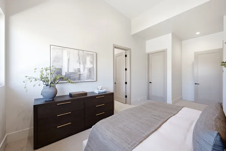 Vaulted ceiling, recessed lighting, light-toned walls, and multiple panel doors with dark hardware