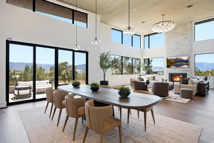 Spacious open-concept living area featuring a stone-clad fireplace and wood-finish flooring