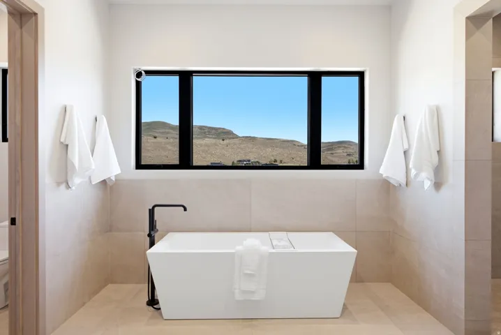 Freestanding soaking tub with a floor-mounted matte black faucet