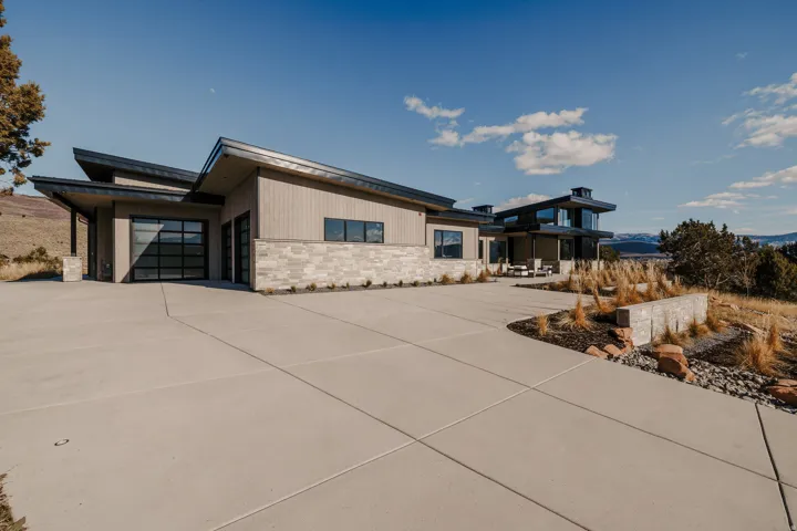 Contemporary architecture featuring a multi-level design, angular rooflines, and a segmented garage door