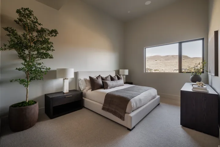 Vaulted ceiling, recessed lighting, expansive window, carpet flooring, and contemporary wall-mounted artwork