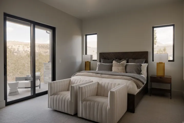 Sliding glass door leading to an outdoor terrace with stone accents, accompanied by two fixed-pane windows